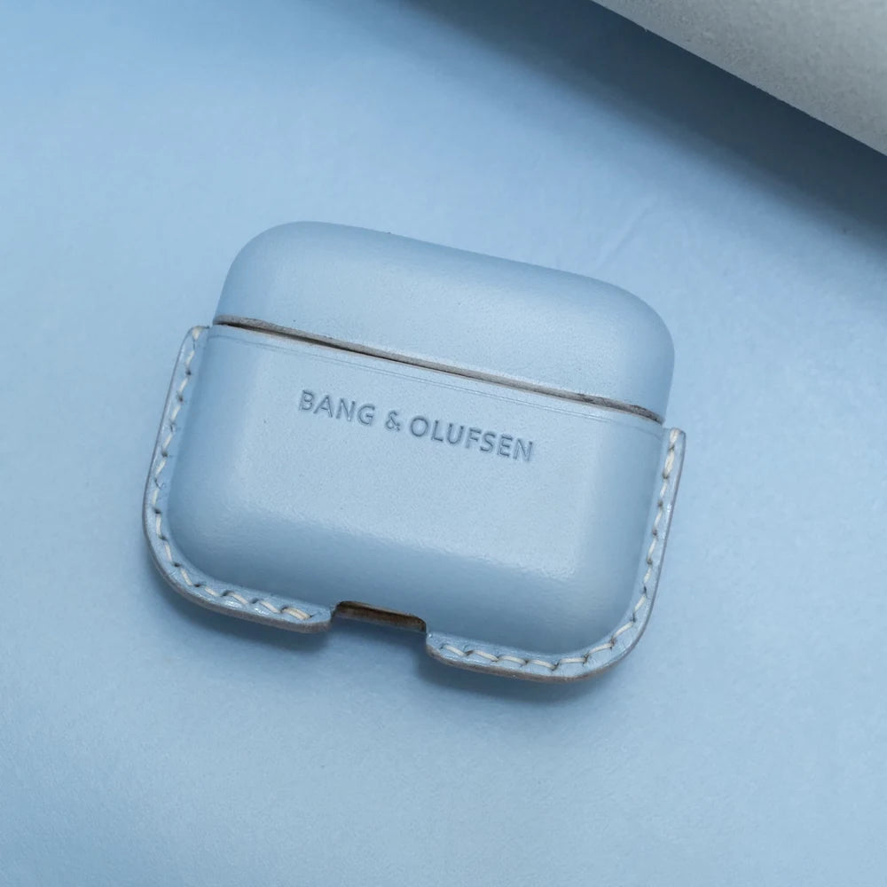 Bang & Olufsen Beo Grace glacier blue leather earbuds case, closed front view on a matching blue background