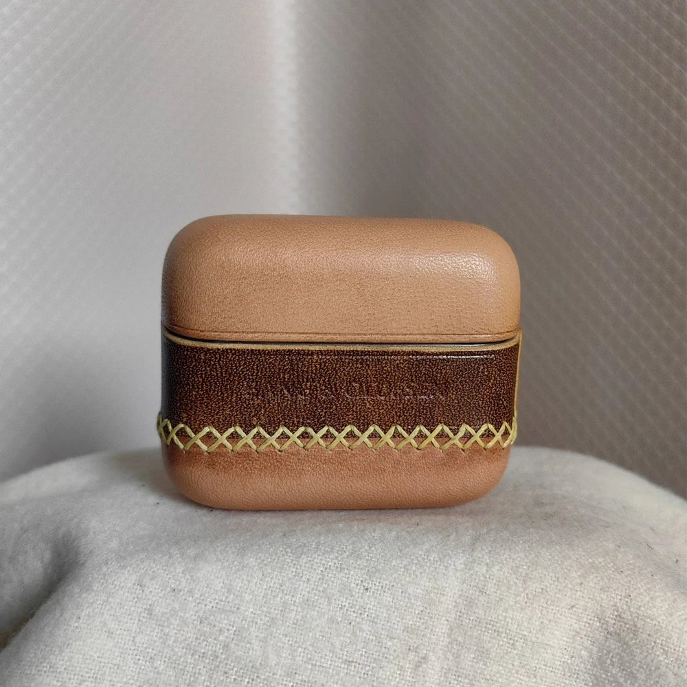 Close-up of a nude and coffee brown leather case for B&O Beo Grace, highlighting the rich coffee brown central band with the embossed Bang & Olufsen logo, contrasting against the lighter nude leather, and featuring intricate yellow-gold X-pattern hand-stitching.