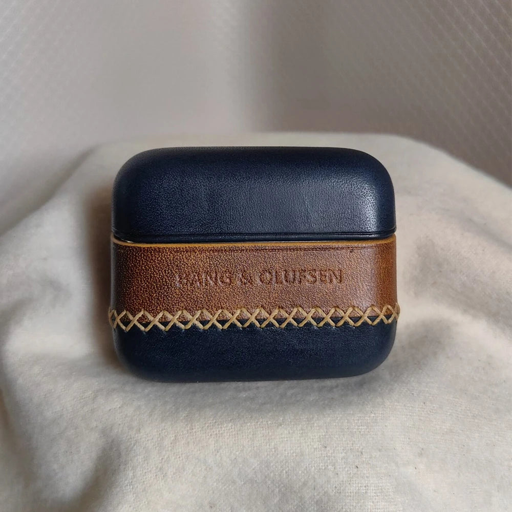 Detailed shot of the Navy Blue leather earbuds case for B&O Beo Grace, accented with a rich brown central band and contrasting yellow-gold hand-sewn stitching.