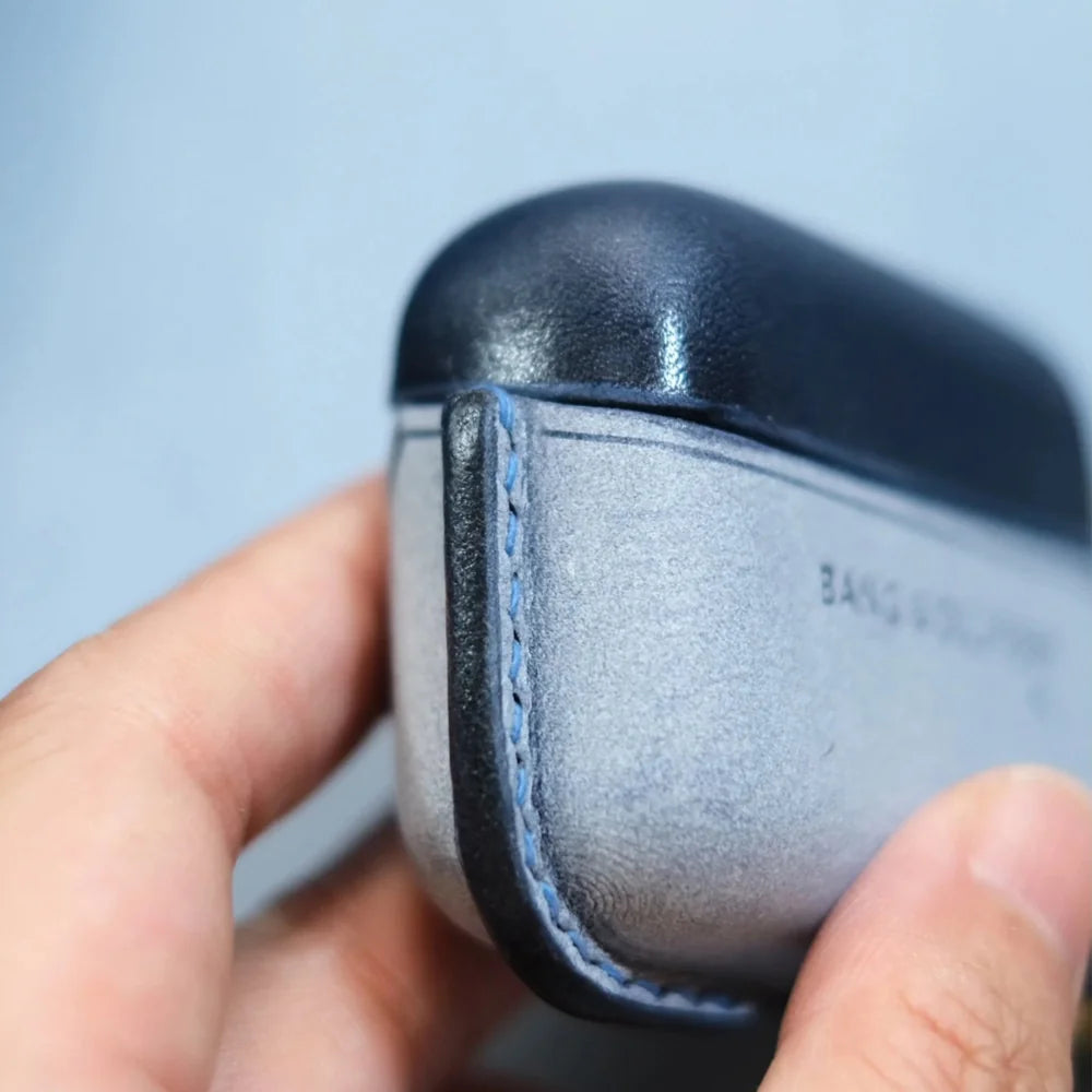 Close-up of handcrafted oily burnished edges and blue side stitching on navy blue and misty wax navy blue leather case for Bang & Olufsen Beo Grace.