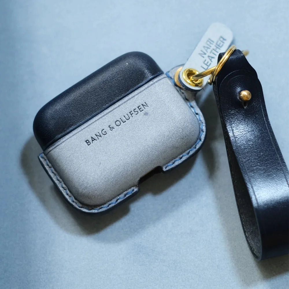 Overhead view of handcrafted navy blue and misty wax navy blue two-tone leather earbuds case for Bang & Olufsen Beo Grace with side wrist strap