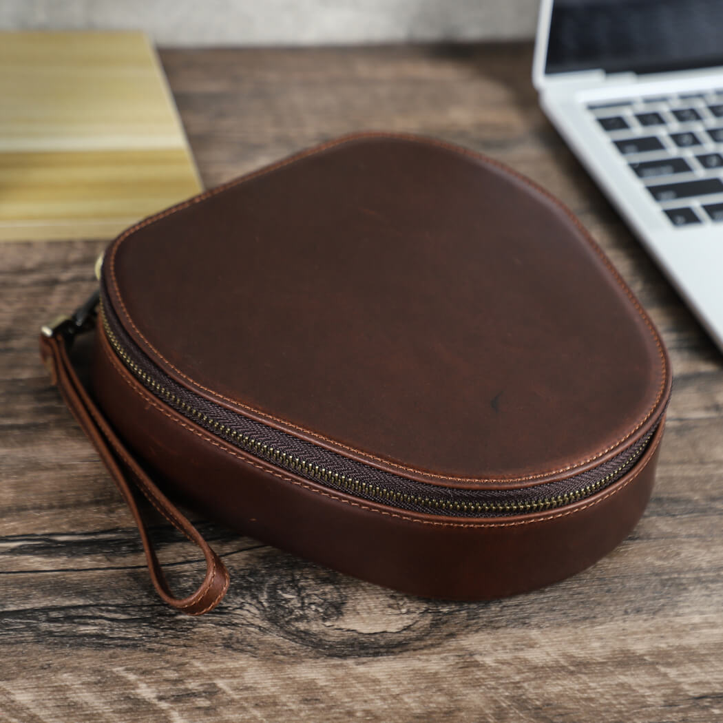 Handmade Full Grain Leather Carrying Bag Case for Sony WH-1000XM6/ XM5/ XM4 Headphones on a wooden surface with a laptop in the background