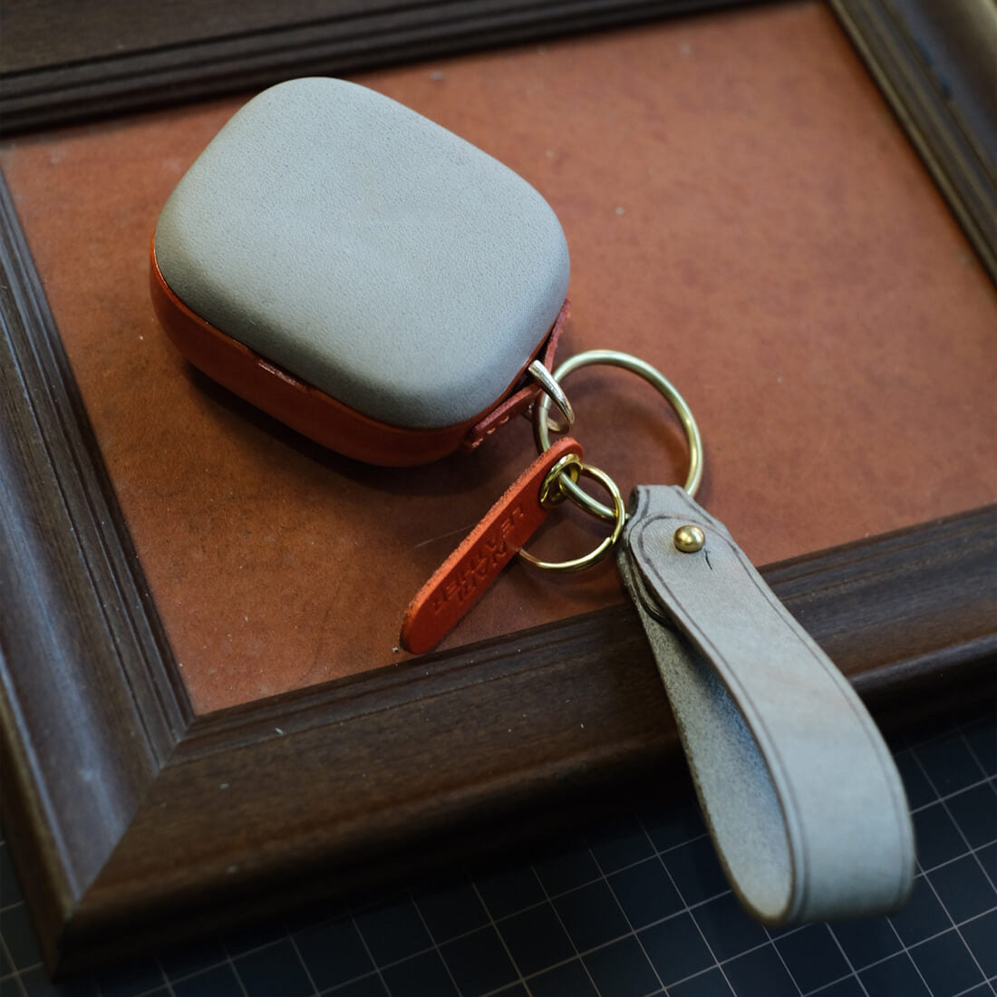 Estojo em pele genuína personalizado e feito à mão para o Beyerdynamic AMIRON 300 em cinzento superior e laranja inferior, a condizer com o porta-chaves lateral e a correia em pele