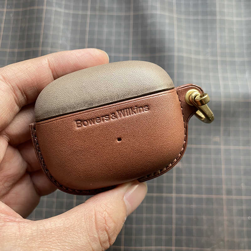 Echtes Lederetui für die Bowers & Wilkins Pi8 Pi6 Bluetooth-Kopfhörer - Nahaufnahme einer Hand, die das Etui in Elefantengrau (oben) und Dunkelkaffee (unten) mit Metallverschluss hält
