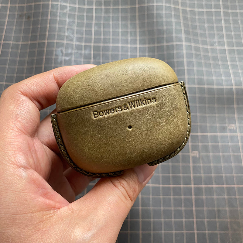 Genuine leather protective case for Bowers &amp; Wilkins Pi8 Pi6 bluetooth earbuds — close-up of a hand holding matte green case with metal clasp