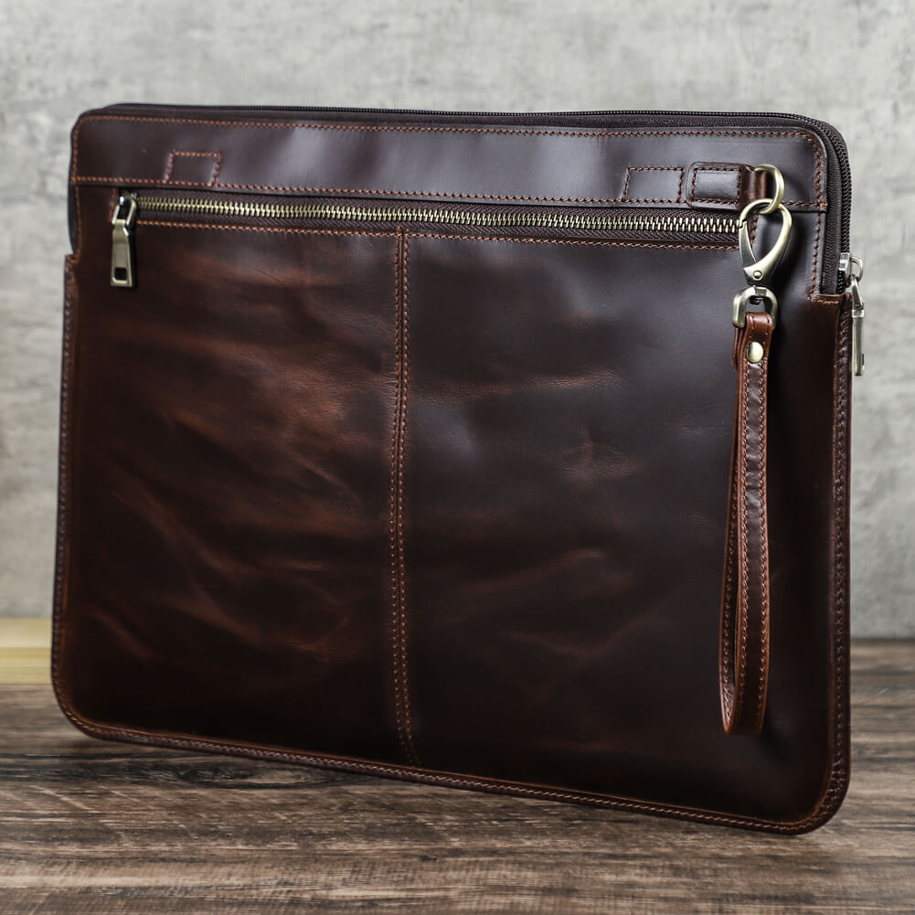 手作りのフルグレインオイルビーズレザー製ノートパソコン用ジッパー付きスリーブバッグ（16インチMacBook Pro対応、手首ストラップ付き） - 机の上に縦置きしてスリーブの外観を展示