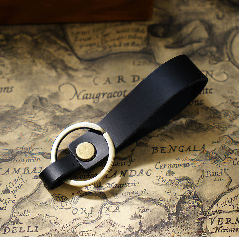 Handgefertigter Schlüsselanhänger aus Vollnarbenleder mit Metallring in Schwarz für Autoschlüssel und Ohrhörer-Etui – Details in Nahaufnahme