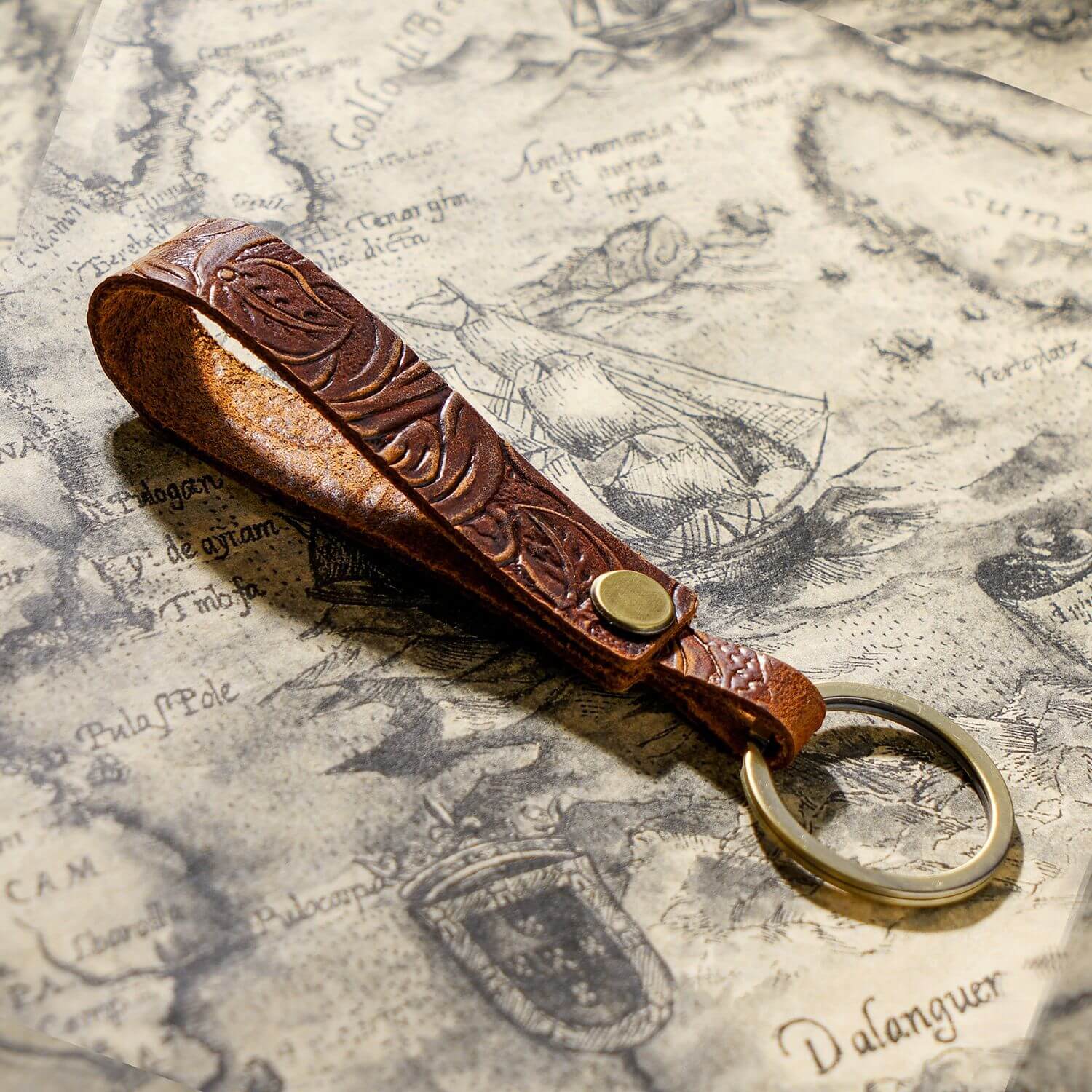 Handgefertigte Schlüsselbandhalterung aus Vollnarbenleder mit Metallring für Autoschlüssel und Ohrhörer-Etui in geschnitztem Blumenmuster, braun, Nahaufnahme