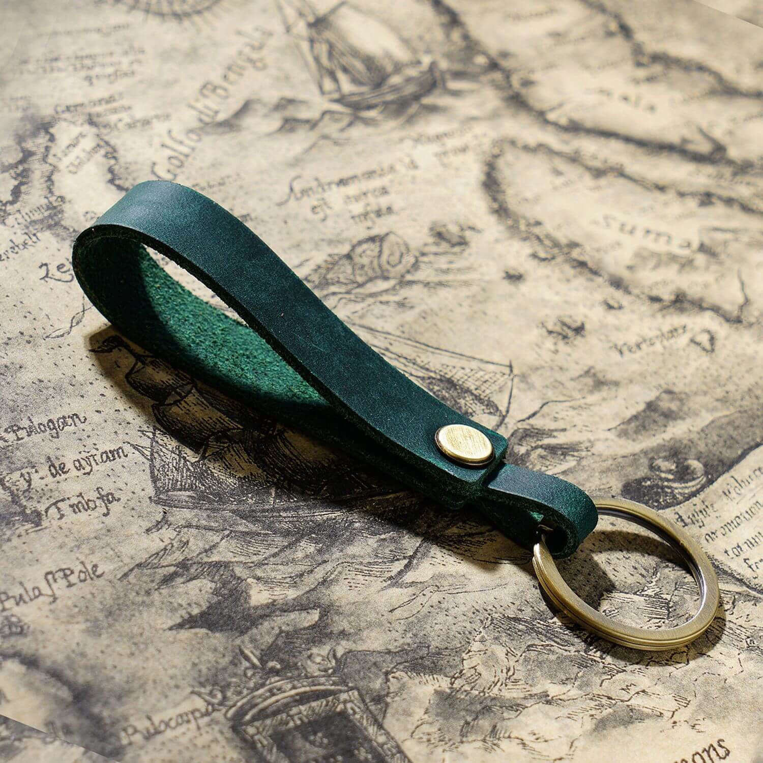 Handgefertigter Schlüsselanhänger aus Vollnarbenleder mit Metallring für Autoschlüssel und Ohrhörer-Etui in Dunkelgrün, Nahaufnahme