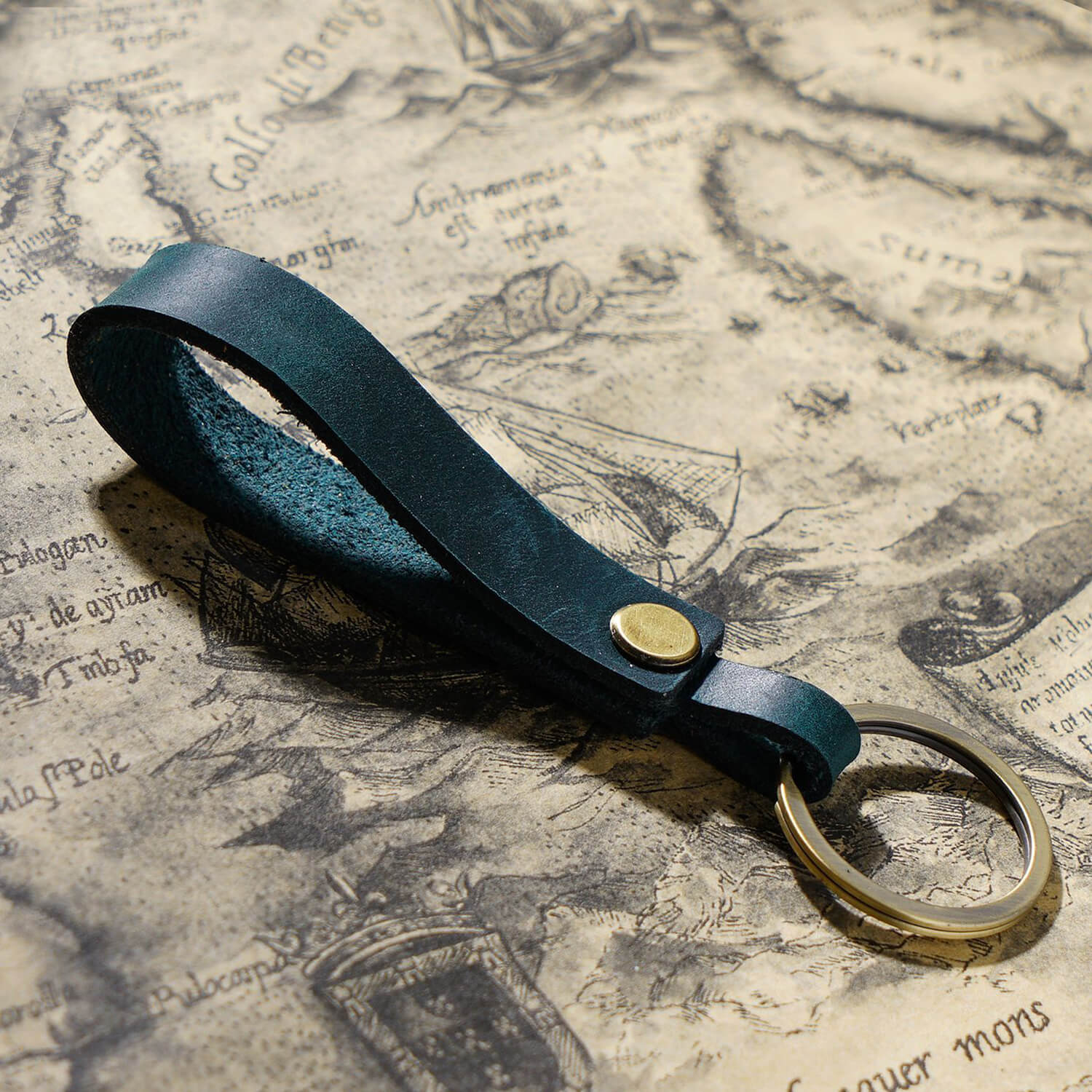 Handgefertigter Schlüsselanhänger aus Vollnarbenleder mit Metallring für Autoschlüssel und Ohrhörer-Etui in Pfauenblau, Nahaufnahme