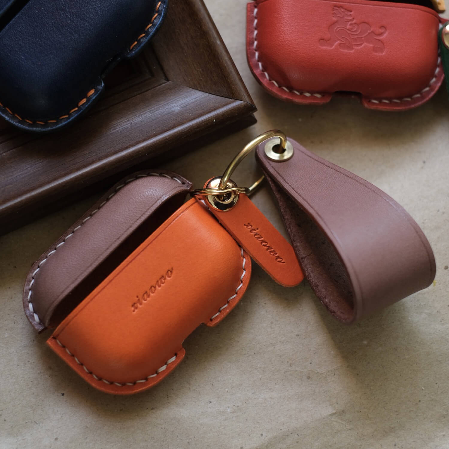 Two-tones light brwon and orange handcrafted leather earbuds case for AirPods Pro 3 with custom engraved text, showing premium stitching and personalized design options