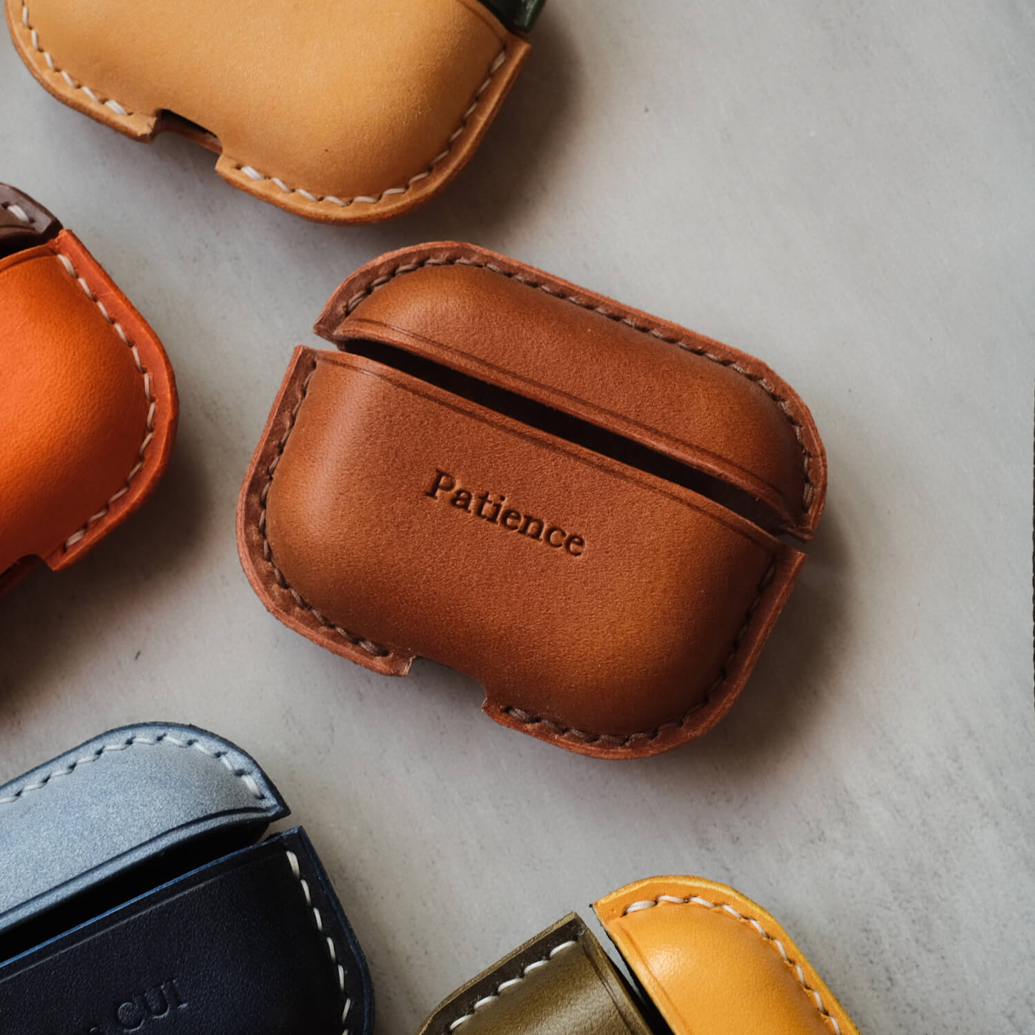 Handcrafted leather earbuds case for AirPods Pro 3 in reddish brown with custom engraved text "Patience" personalized design.