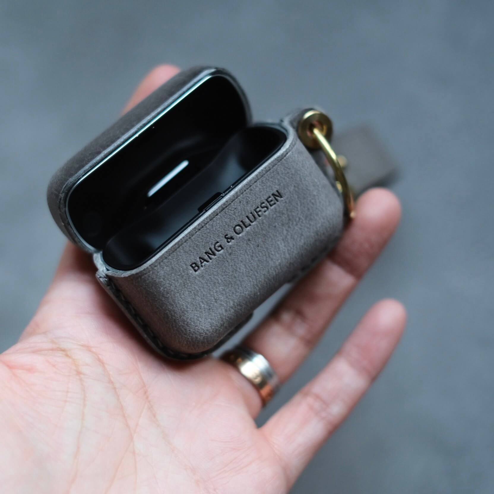 Étui pour écouteurs en cuir gris éléphant personnalisé et fabriqué à la main pour Bang & Olufsen Beo Grace avec porte-clés latéral et sangle en cuir - ouverture du couvercle en gros plan