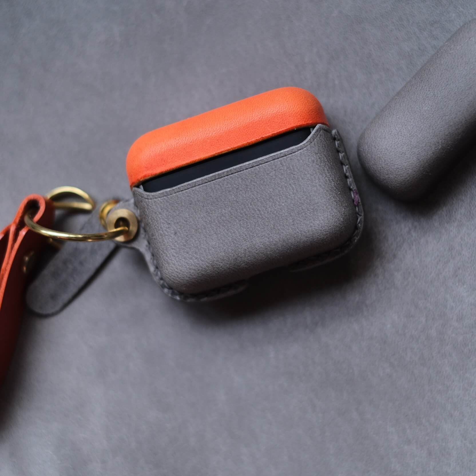 Étui pour écouteurs Bang & Olufsen Beo Grace en cuir orange et gris éléphant, personnalisé et fabriqué à la main, avec porte-clés latéral et lanière en cuir orange - vue arrière en gros plan