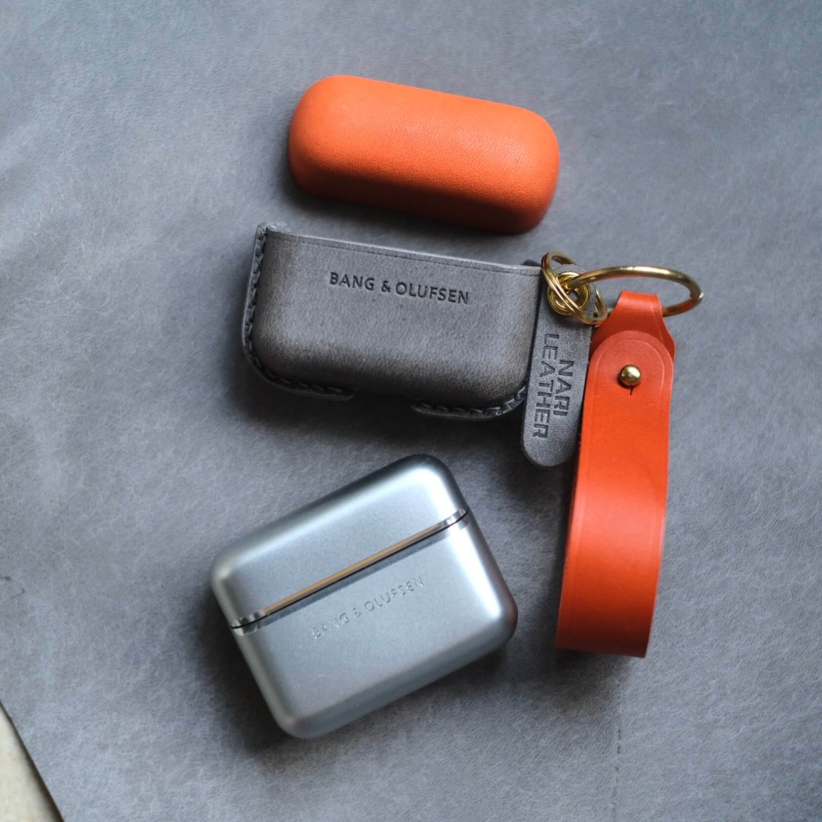 Étui personnalisé en cuir orange et gris éléphant pour écouteurs Bang & Olufsen Beo Grace avec porte-clés latéral et lanière en cuir