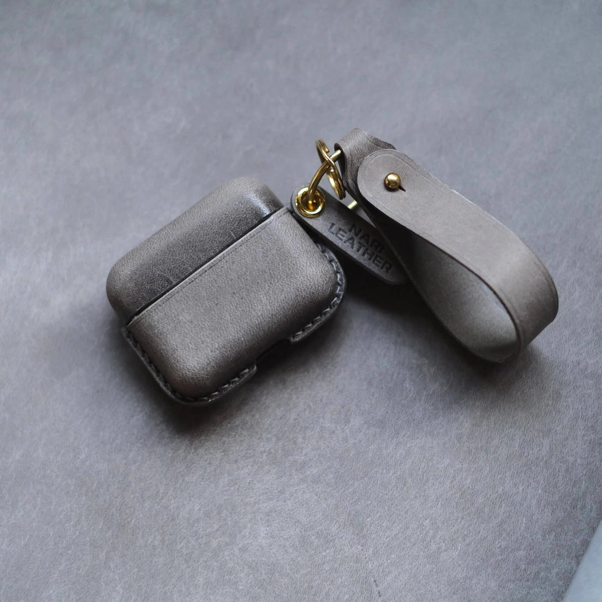 Handcrafted custom personalized elephant grey leather earbuds case for Bang &amp; Olufsen Beo Grace with portable side metal ring and leather wrist strap - top view