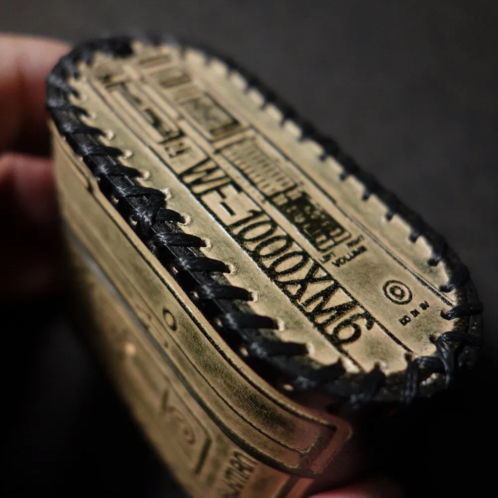 Detailed top close-up of the Sony WF-1000XM6 leather case, showing the black printed model name and intricate retro embossed design.