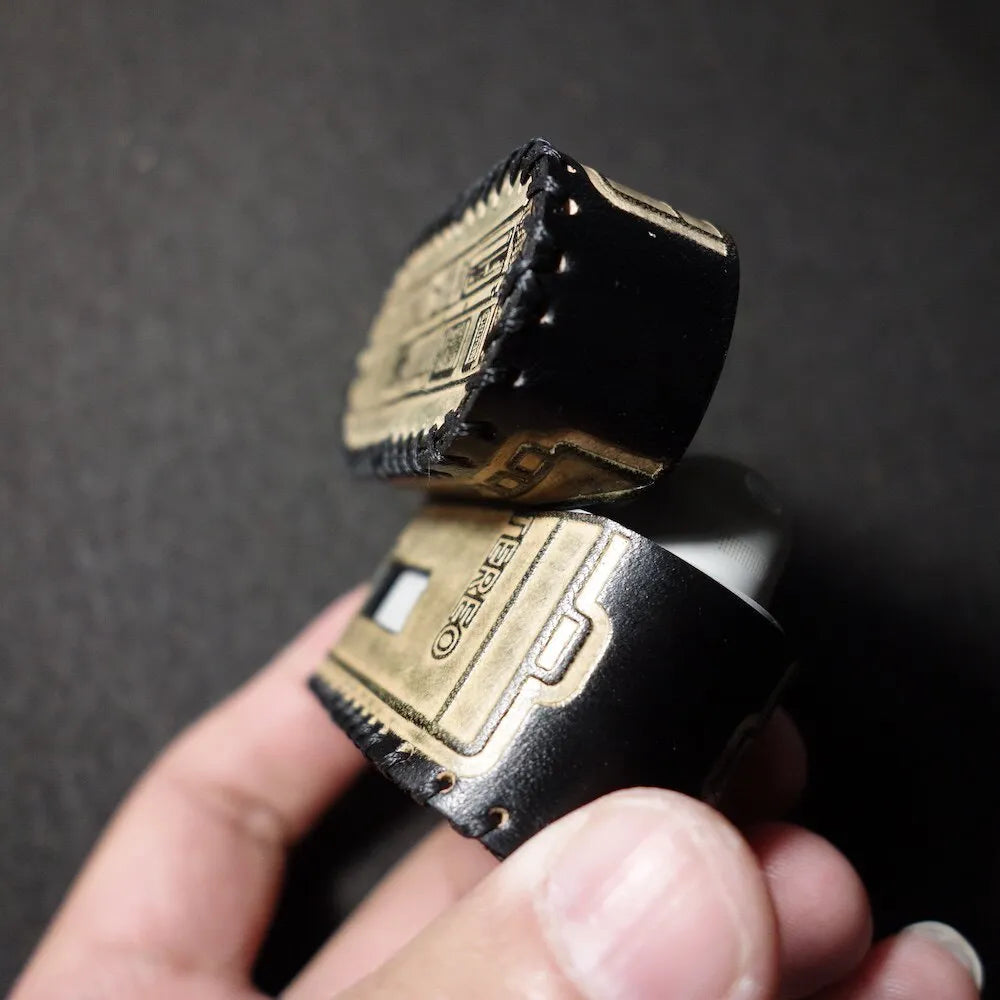 Hand-held side view of the Sony WF-1000XM6 black leather case opened, showcasing the premium tactile feel and vintage hand-stitched craft.