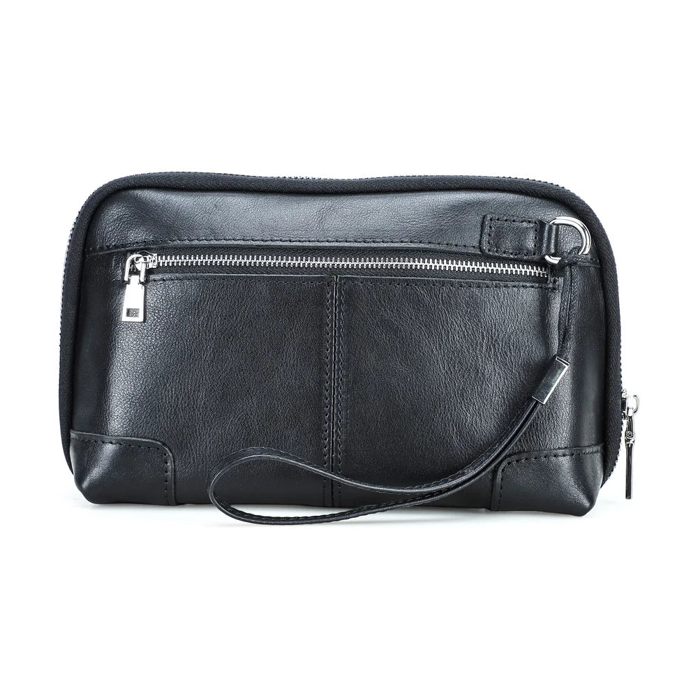 Back view of a handmade black vegetable-tanned leather clutch bag with a front zippered compartment, metal D-ring, wristlet strap, and silver hardware.