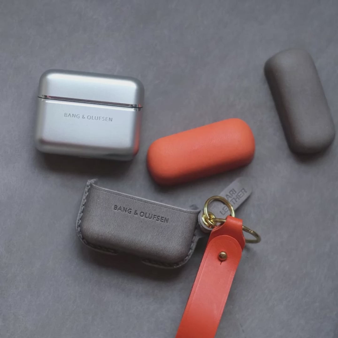 Handcrafted custom personalized orange and elephant gray leather earbuds case for Bang &amp; Olufsen Beo Grace with side keychain and orange leather strap