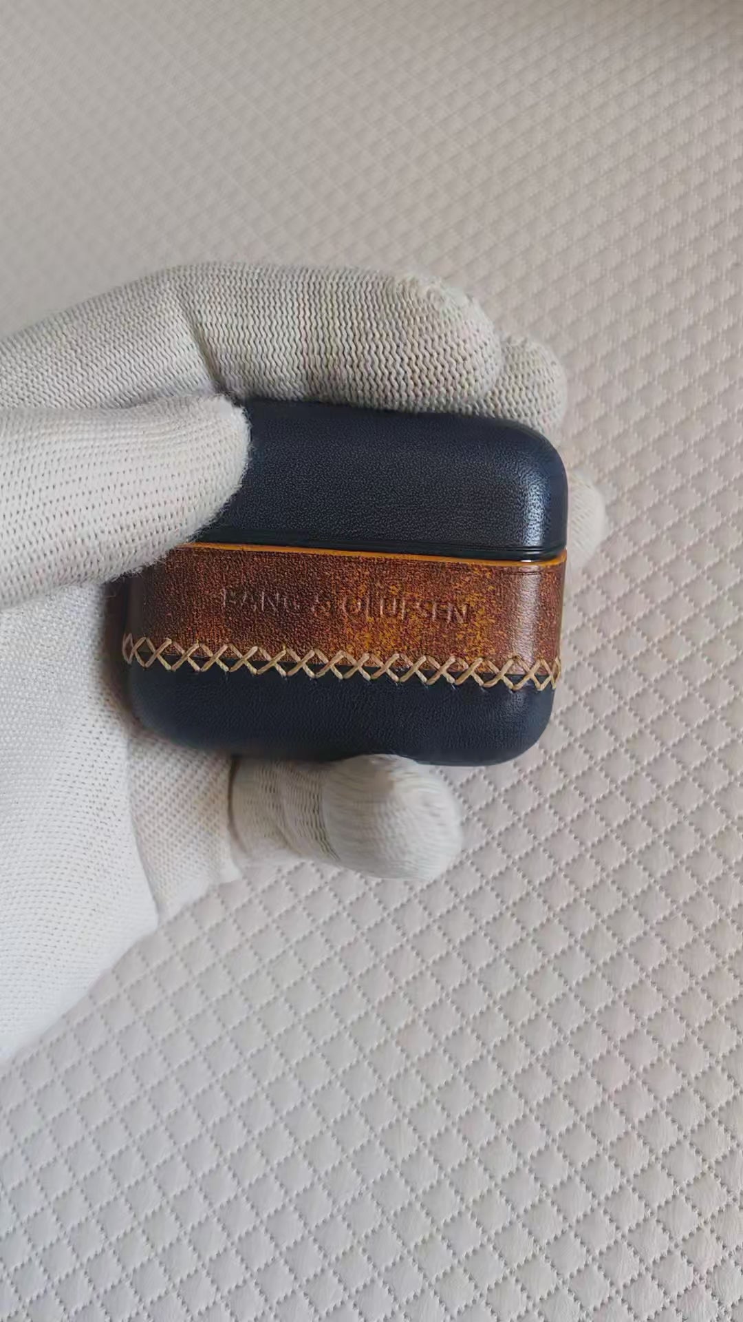 Product video of handmade Navy Blue and Brown leather case for Bang & Olufsen Beo Grace, showcasing the premium full-grain texture, artisan yellow cross-stitching, and 360-degree protective fit.